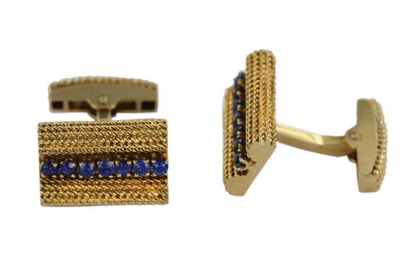 These mid-century Tiffany cufflinks feature a single row of brilliant blue sapphires set into a rectangle of woven, herringbone-patterned 18K gold.