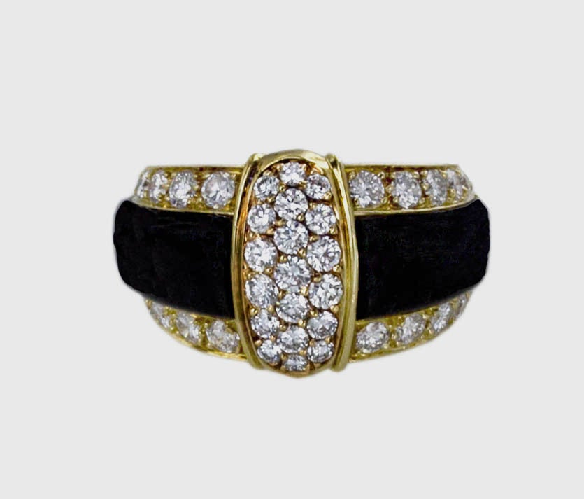 Pure 80’s style from Van Cleef & Arpels is seen in this dramatic ring featuring a 3-row panel of round diamonds framed in high-polish 18K yellow gold, and centered on a wide black onyx band flanked on either side by a single row of diamonds set into