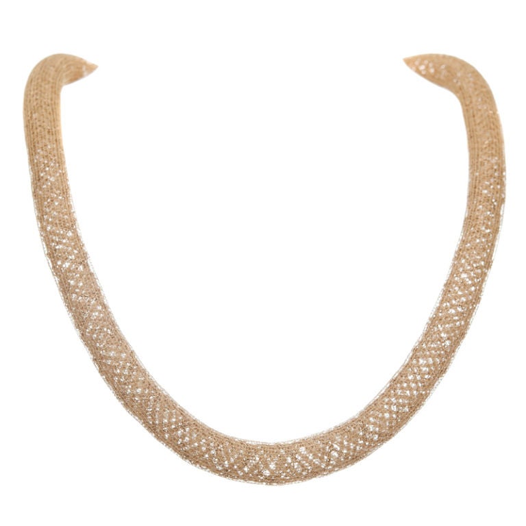This unique necklace is light, airy and versatile. Almost spongey in texture, a delicate gold braid is covered in a second layer of fine golden mesh.
