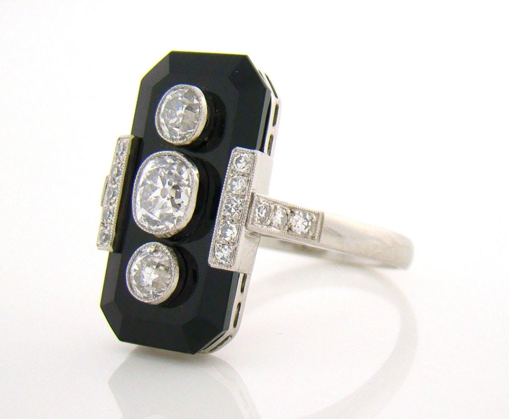 Diamond & Onyx Art Deco Style Platinum Plaque Ring containing two Old European cut diamonds and one Old Mine Cut Diamond totaling 1.36 carats plus an additional 16 smaller diamonds in detailing. Handmade with a very low profile makes this ring is