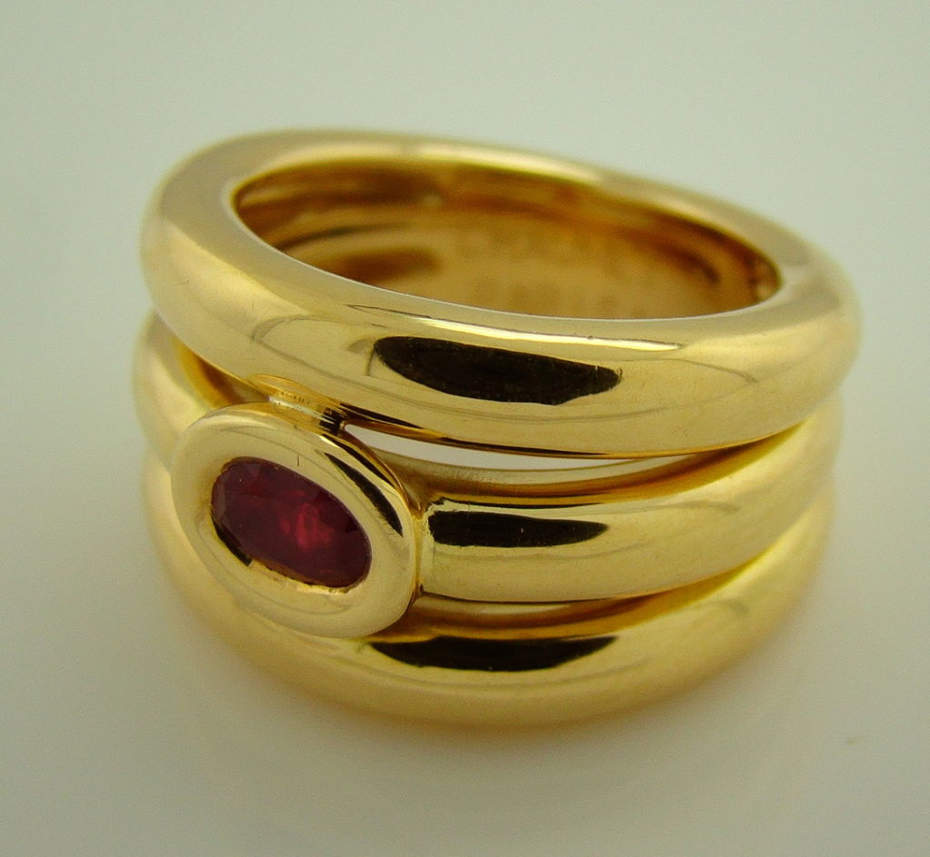 A beautiful tiered succession of golden round rows, hand crafted with one (1) fine ruby center. A clean design that is both unique and subtly chic. A fantastic and affordable designer ring handmade in Paris by the fine fashion house Chaumet.