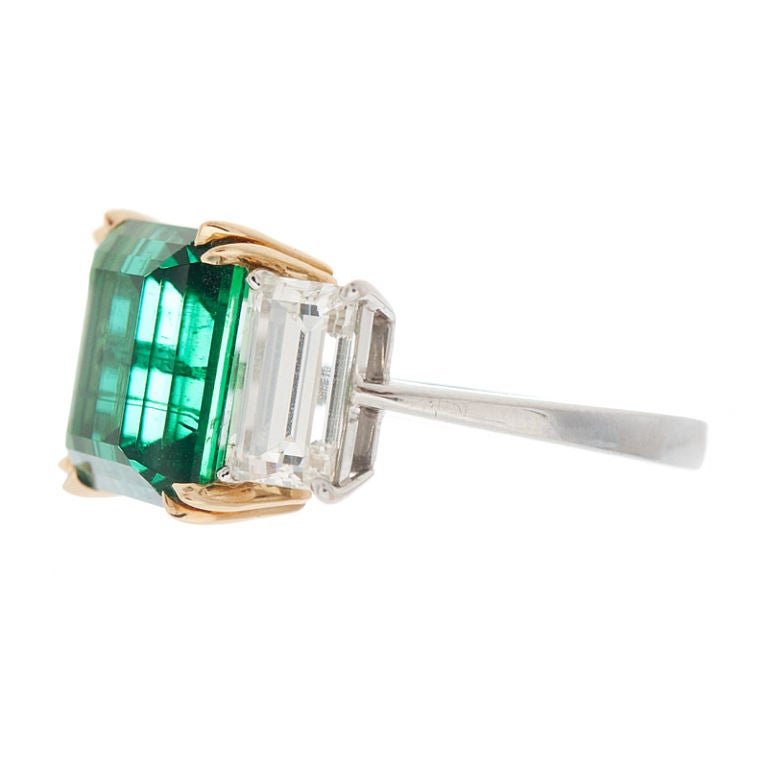 Magnificent Emerald Cut 4.17 carat Emerald Ring with an Emerald Cut Diamond on each side of the emerald weighing approximately 2.00 carats in total diamond weight. This is a platinum ring with the exception of the part of the setting holding the