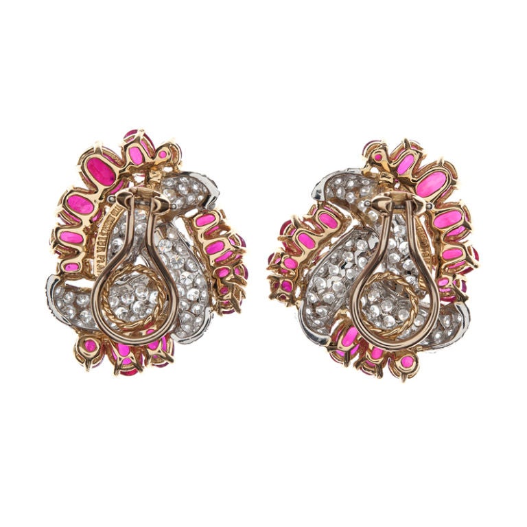 Elegance abounds in these incredible earrings. 26 sumptuous oval cut rubies, weighing 11.58 carats total, embrace the center diamond cluster, 5.36cttw. Glamorous and sophisticated,  signed 