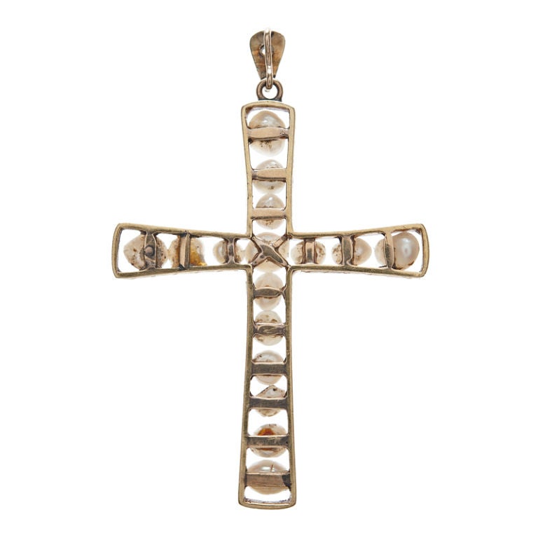 A unique cross design with 100 year old provenance, made circa 1910 it is handmade and set with natural pearls. The largest natural pearl lies at the center, moving sequentially down and then up in size as they approach the periphery of the sides of