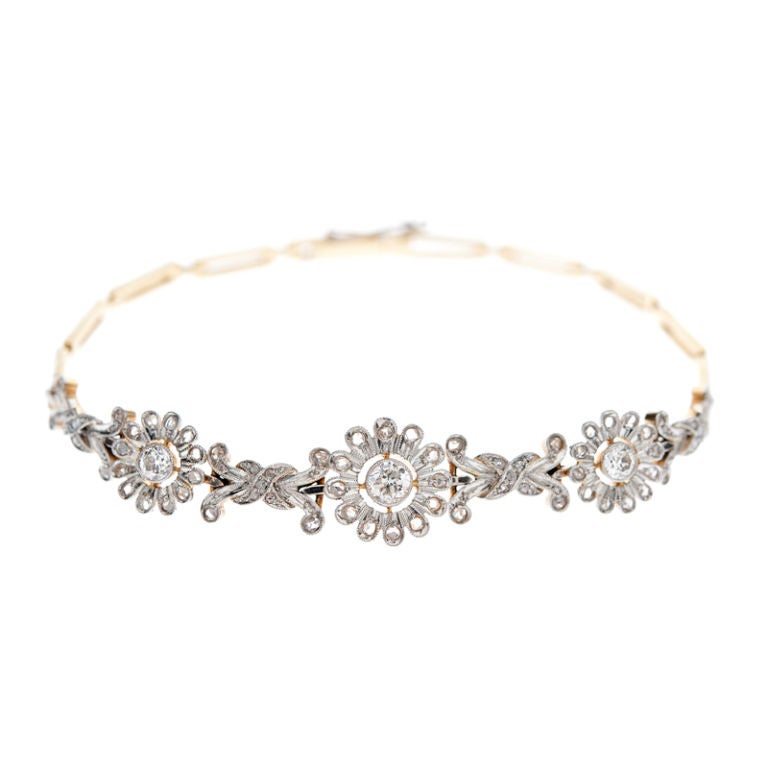Delicate blossoms are the focus on this dainty Edwardian bracelet. Rendered in platinum over yellow gold, three Rose Cut diamond flowers gracefully drape across the wrist-a lovely and feminine bracelet!