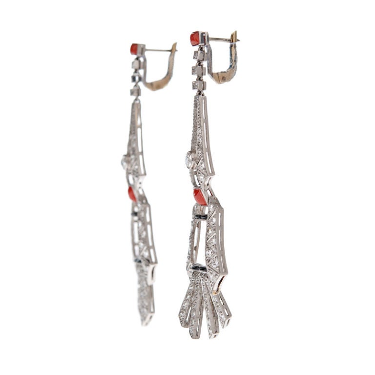 Handmade platinum, diamond, onyx and coral dangle earrings. Finely crafted and well designed with beautiful and fun movement throughout. The platinum mounting boasts beautiful design with masterfully symmetric hand piercing, set with 108 diamonds