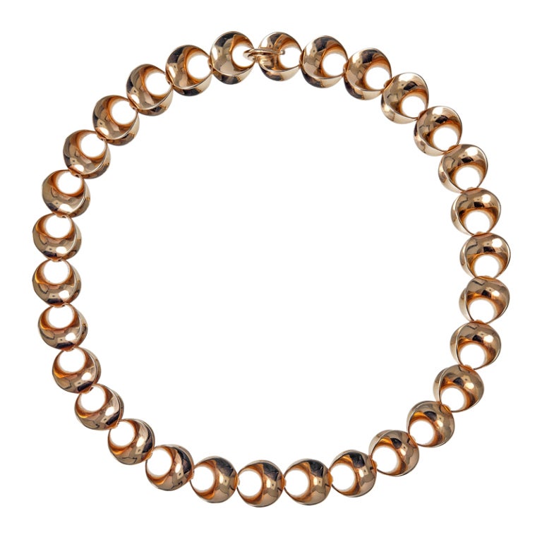 A sophisticated yellow gold necklace fashioned with a unique element of 1980's bohemian flavor. Executed with masterful craftsmanship, this inventive design is 3-Dimensional and undeniably elegant. An overall incredible period necklace combining 