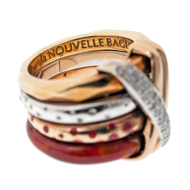 A gorgeous Italian design by fine jeweler la Nouvelle Bague. Four separate 18k gold bands are stacked atop each other and allow some movement, fastened by a crossing pattern of diamonds over gold. Each band is stylized differently, rejecting pattern