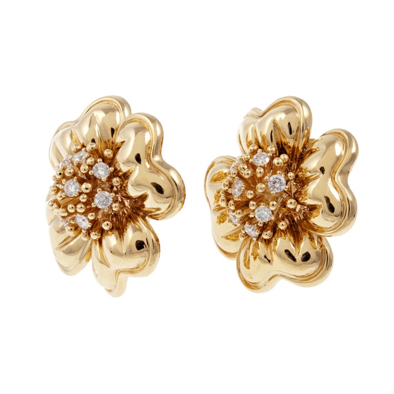 Gleaming petals of gold surround a cluster of sparking white diamonds to create a three dimensional flower. In total 1.25 carats of diamonds are nestled among beads of gold, causing the earrings to come to life. Currently a clip with an Omega style