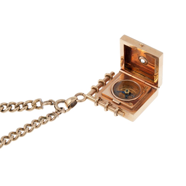 Never lose your way... Platinum and 18 karat rose gold locket pendant with a compass cleverly concealed inside, dotted with an old mine cut diamond. The antique rose gold chain measures just 14.5 inches and clasps in the front. This is a fun,
