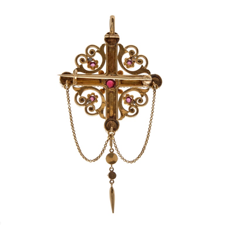 Stunning yellow gold Victorian Brooch dotted with cabochon garnets and finished with black and white enamel. The style resembles a modified cross. A gold bale is concealed at the back, so it can be easily flipped up and worn as a pendant. This piece