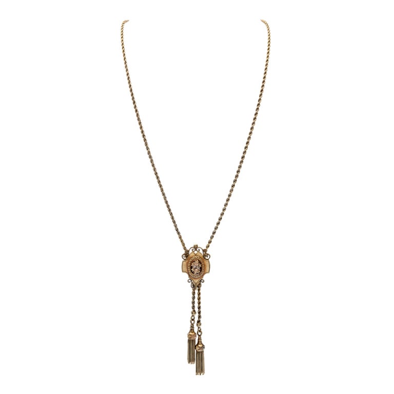 Classic Victorian design at its finest... Beautifully made and preserved pendant with yellow, white and rose gold flowers, scrolls and braided tassels of gold, hinged to allow for ideal movement and on a hand made woven chain of gold which measures