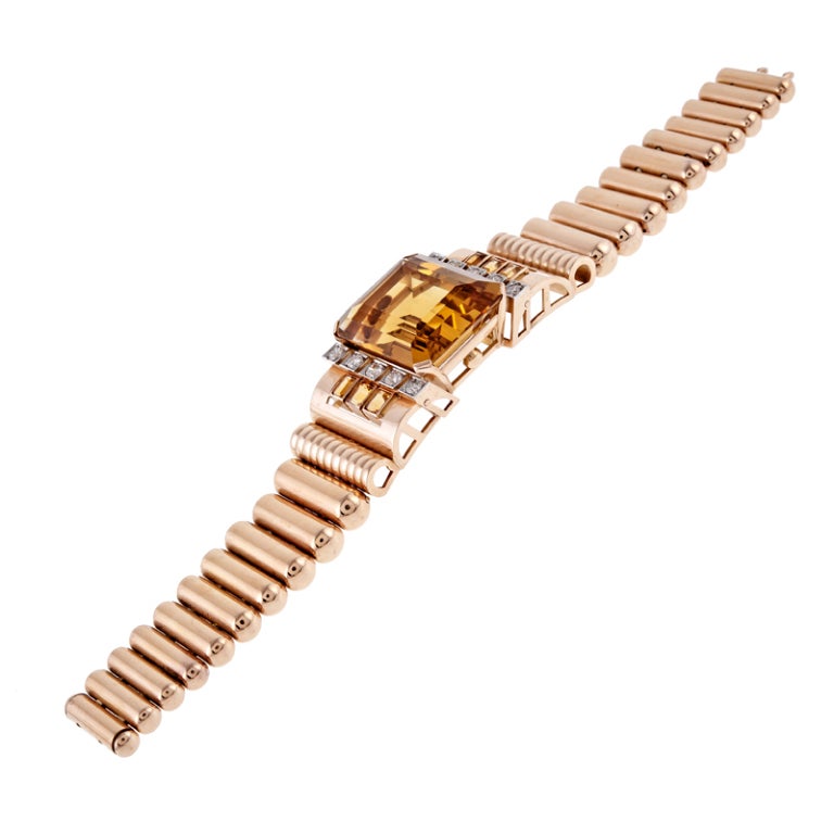 A 55 carat citrine sits at the center of this high-style retro bracelet like a crown atop a queen's head. The stone is flanked by a row of round brilliant diamonds, set in square platinum bezels. Descending therefrom is a row of emerald cut