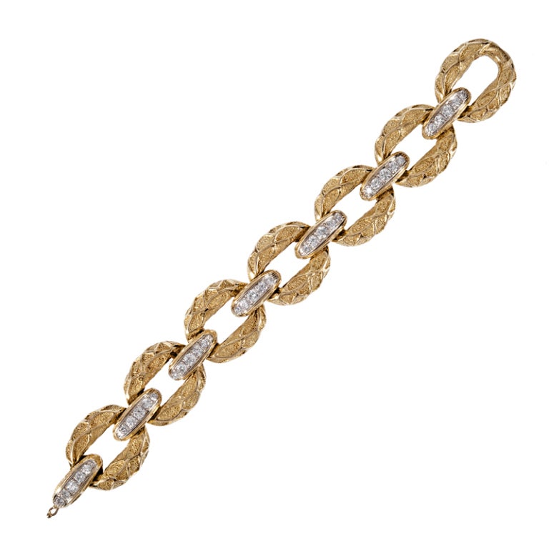 Abundant both in substance and design, this weighty hand made bracelet comes compliments of Hammerman Brothers. The combination of textured gold and a high polished pattern on the links creates an almost 