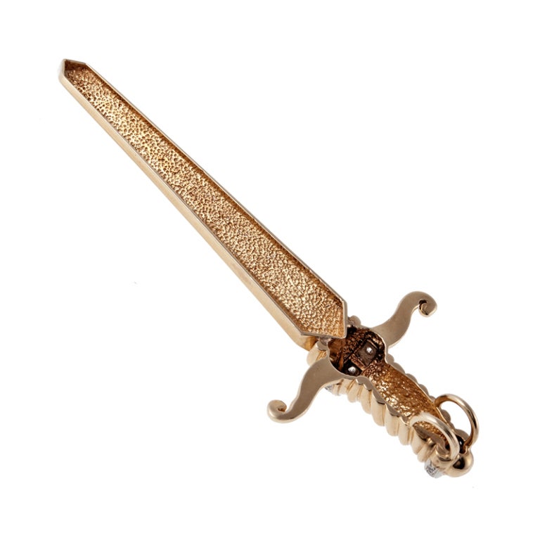 Substantial in look but light weight, a bold diamond and yellow gold sword pendant. This sword is made in 14k yellow gold, adorned with 14 diamonds weighing 0.33 carats in total. A fun and flavorful item of jewelry, measuring 3.6 inches in height by