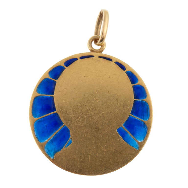 Stunning depiction of the Virgin Mary, bathed in glorious blue light from the plique a jour enamel halo aura surrounding her profile. This medallion is crafted of 18 karat yellow gold and  is rather weighty and substantial. It is signed on the