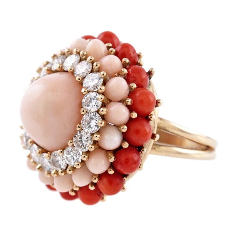 A lovely example of classic 1950s jewelry, this ring has such style, it could be an important cocktail ring or a playful compliment to your summertime attire.

Designed as a play on a classic cluster style, with a single cabochon cut angel skin