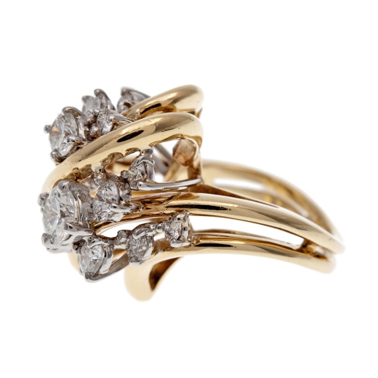 Sweeping strokes of polished gold provide an unusual mounting for clusters of brilliant diamonds. Twenty round diamonds of various sizes weigh approximately 2 carats in total. Each stone is prong set and builds upon the next, with the layers forming