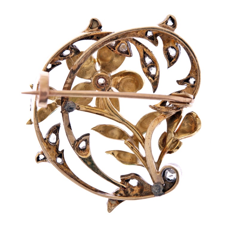 Feminine and beautiful art nouveau brooch, in a pleasant and modest size, rendered in silver over yellow gold. This piece embodies all that collectors love about this period. Fine enamel flowers of peachy hues are complimented by bright green leaves