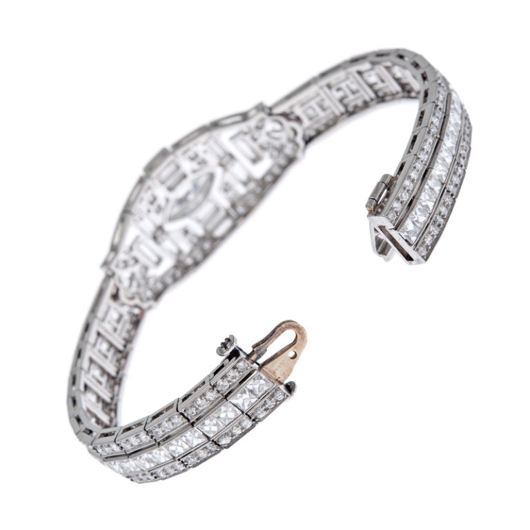 Immaculate art deco platinum bracelet, with a unique deign. At its center, a marquis diamond of .85 carats which grades as E-F color, Vvs clarity. Surrounding the major diamond is an exquisite gallery of filigree, millegrain, bezel set baguette