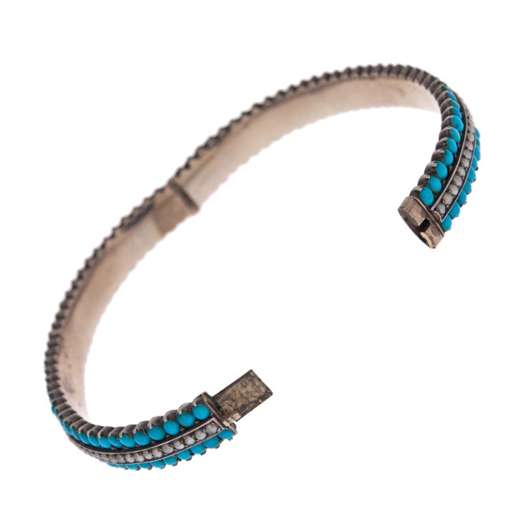 Charming antique bracelet, forged in sterling silver. The piece once was plated in rose gold, however, much of it has worn away over time and just a gentle warm hue remains. 

An alternating row of turquoise and natural pearls makes up the