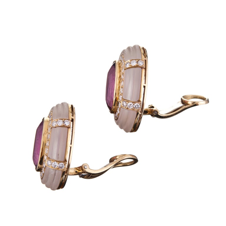 18k yellow gold ear clips with substantial and lively rubelite centers (16 cttw), accented with approximately 2 carats of diamonds and carved rock crystal. Very sophisticated, with a playful twist. These could easily be converted to pierced