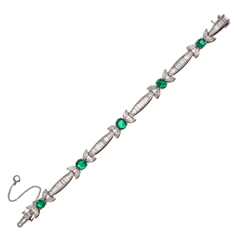 Gorgeous platinum bracelet with 10.76 carats of bright white baguette and marquis cut diamonds highlighted with 4.75 carats of cabochon emeralds. This piece embodies all that is celebrated about 1950s jewelry, with the cab emeralds at the center of