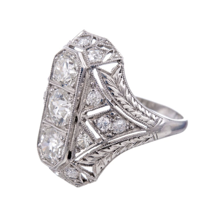 Classic art deco plaque ring with three old European cut diamonds weighing 1.35 carats in total going down the center and an additional fourteen old European cut diamonds artfully placed as accent stones. This ring offers an impressive design and