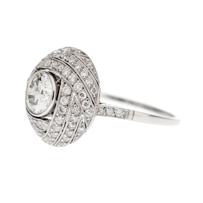 A round diamond, set in a soft platinum bezel and recessed in a 