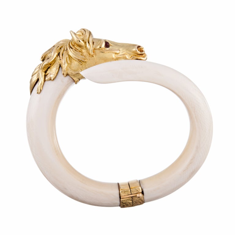 Staff favorite: Realistically designed horse head in 18k yellow gold with a finely textured mane of golden hair, set atop a bangle of smooth, carved ivory. The bracelet swivels to one side to allow it to comfortably slip on- and off the wrist.

A