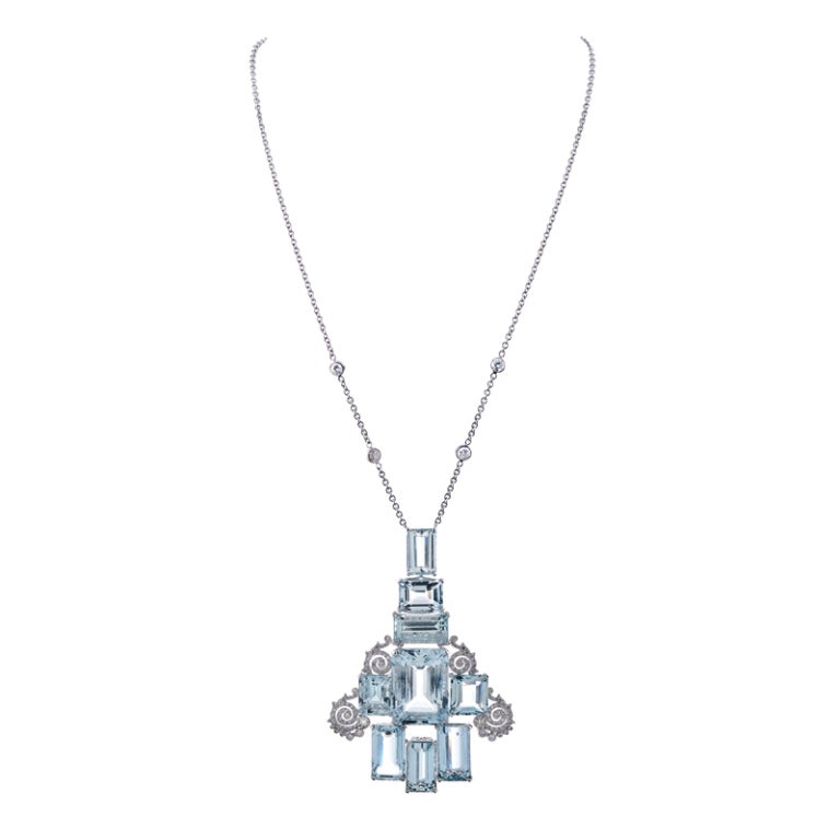 Set in 18k white gold, this substantial, yet feminine pendant consists of nine aquamarines weighing a combined 70 carats, complimented with scrolling swirls of diamonds. Each aqua s set in its own four-prong cup and the sides are finished with