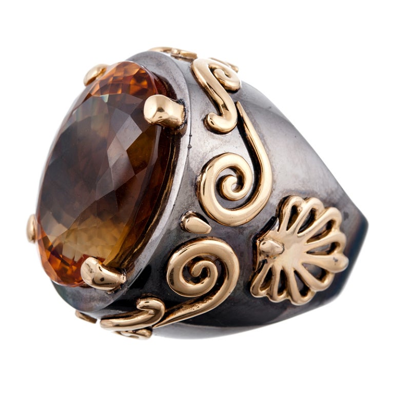 A truly unique piece, most certainly a custom-made ring, made of black rhodium plated 18k white gold and decorated with three dimensional yellow gold filigree. The center is a large citrine which exhibits lovely and intense color. Currently finger