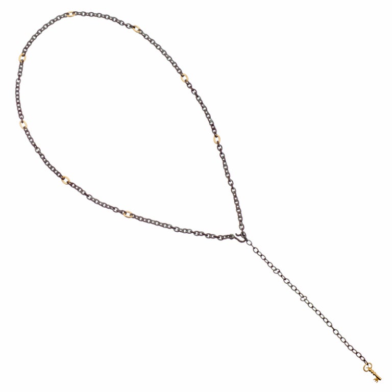 24 inch chain of oxidized sterling silver, fitted with eight links of 24k yellow gold and finished at the end with a stylized hook. The final six inches are more modest in substance- the intention is to fasten the hook at whichever length suits you