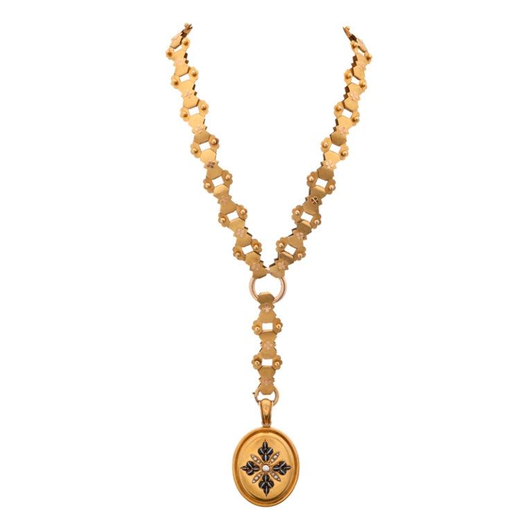 Stunning, substantial Victorian locket on a massive and impeccably-preserved stylized chain. The chain is a half inch wide and is comprised of unusual, geometric links, decorated with a four-leaf clover design and raised orbs of gold. It measures 17