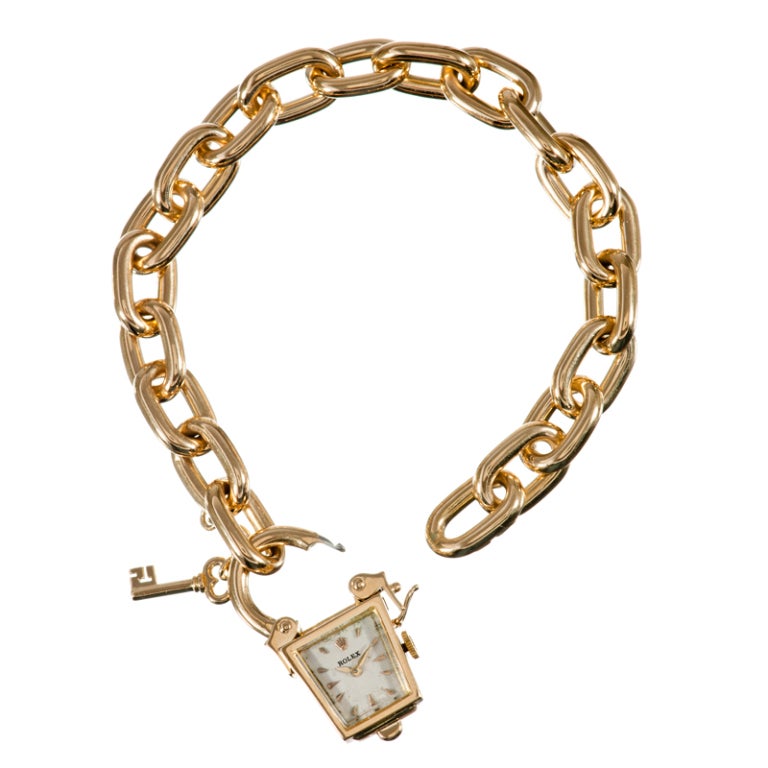 Vintage charm abounds... A truly unique twist on a classic charm bracelet, with an asymmetrical lantern shaped manual wind watch suspended from a chain of oval yellow gold links. Crafted of 18k yellow gold and designed in the style of a classic
