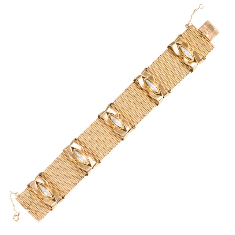 Exhibiting wonderful style and character, this is an exceptional retro piece. The mesh bracelet is just shy of 1 inch wide and is decorated with five high polished knots, each adorned with a diamond-studded centerpiece. 

The bracelet has a lovely