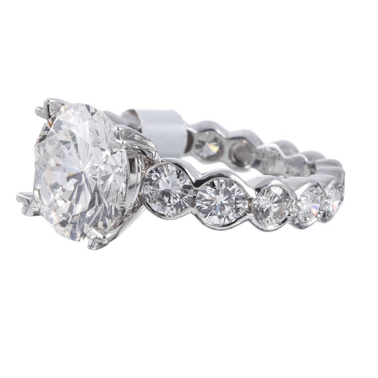 Platinum mounting with 2.80 carats of gently graduated round diamonds in the setting alone. The diamonds go nearly all the ways around the band, with just a bit of space to allow the ring to be sized. The centerpiece is a 5.01 carat brilliant round