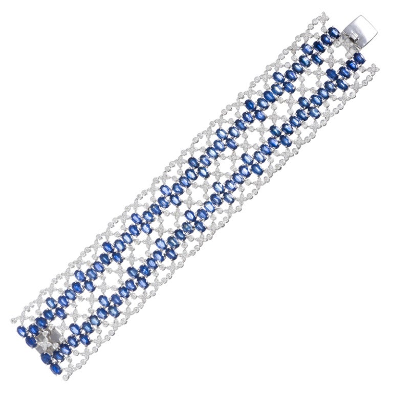 Measuring 7 1/2 inches in length and 1 3/8 inches in width, this diamond and blue sapphire bracelet mounted in white gold is a delicate breath of fresh air,  in spite of the generous stone weight.  The 108 sapphires weigh approximately 35 carats and