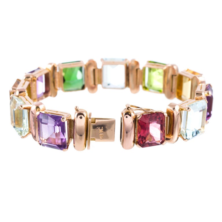 Marvelous retro bracelet consisting of eleven emerald cut gemstones, connected by high polished rose gold sections. Tourmaline, aquamarine, amethyst, citrine and peridot create a dazzling, rainbow-colored fine jewelry bauble to delight you and make