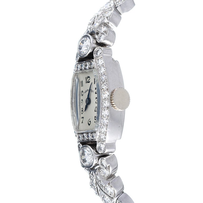 Fantastic lady's platinum and diamond dress bracelet watch, classic 1950s style, with a block bracelet and stylized case. Every inch is covered in diamonds, approximately 4 carats in total. The dial is quite easy to read, considering its modest