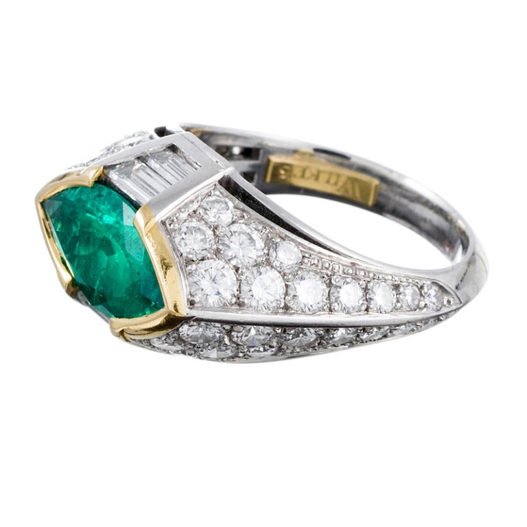 Crafted in platinum, with the emerald set in an 18k yellow gold bezel, this is a unique and sculptural creation. No detail has been spared. Hand made with a lovely combination of round- and baguette diamonds (1.70 cttw) and a fine 2.44 carat marquis