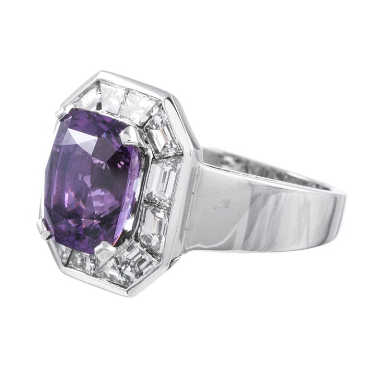 Unusual and very beautiful oval faceted sapphire, nestled in a frame of custom-cut white trapezoid diamonds. The ring is 18k white gold and has a distinctive contemporary edge, yet the wearable nature of a classic cluster ring. The center sapphire