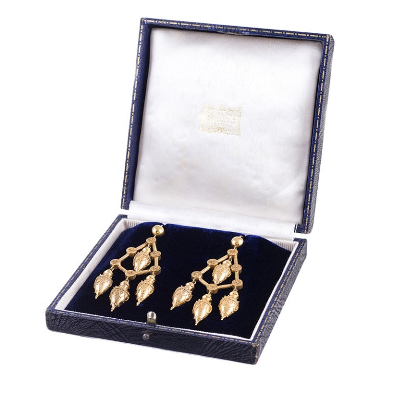 15k yellow gold earrings comprised of finely decorated urn-shaped drops assembled together in a classic chandelier style and connected by golden rods and floral discs. Three inches long and offered in an antique presentation box. These earrings are
