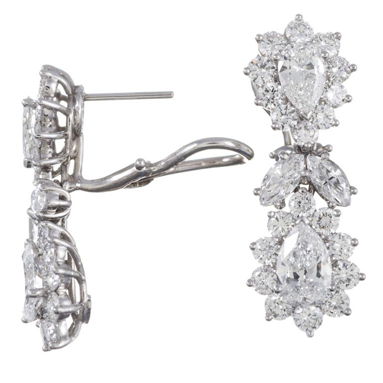 Platinum drop earrings, 1.25 inches in overall length, with a combination of two stacked clusters, a pear brilliant diamond at the center of each one, connected by an opposing pair of marquise brilliant diamonds. Hand-crafted design allows for