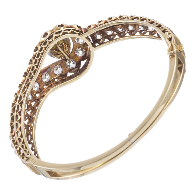18k yellow gold single hinge bangle bracelet decorated with 8 carats of brilliant diamonds and a single 10mm pearl. Sophisticated and classic, yet with the interest of asymmetric design, this is an easy piece to wear alone or layered with other