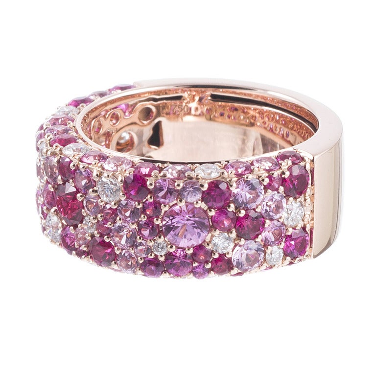 18k rose gold ring, set with a speckled design of brilliant round white diamonds and multiple shades of pink sapphires. In total, there are 4.57 carats of sapphires and .42 carats of diamonds. The ring can be resized modestly or ordered in any size