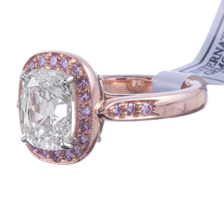 Set in platinum and 18k rose gold, this ring delights all who have encountered it. The center is set with a 3.10 carat cushion cut white diamond, GIA graded H color, Vs2 clarity. The diamond is surrounded by a frame of pink diamonds and has
