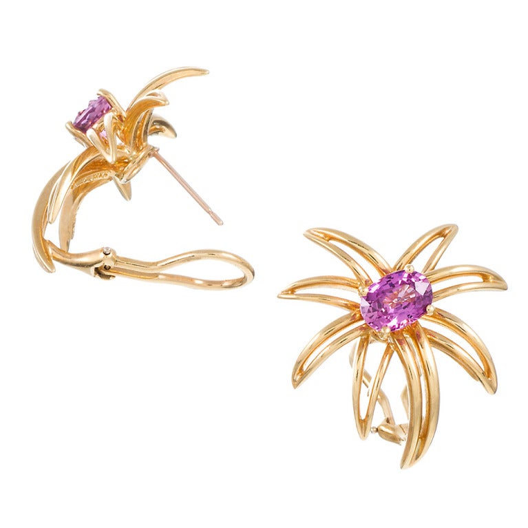 Open gold wirework, formed into an organic shape resembling a starburst and set in the center with a faceted pink sapphire. Made of 18k yellow gold and signed 