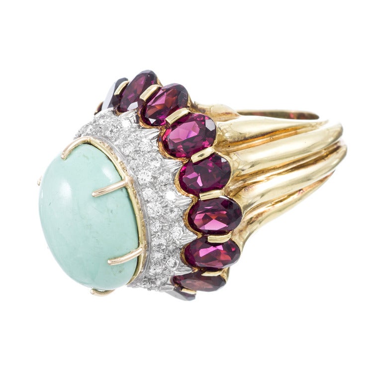 Giant and impressive, with a gorgeous and unusual combination of gemstones, this Henry Dunay ring is a head-turner! A 15 x 19mm turquoise cabochon tops the tiered design, with 1 carat of diamonds and over 17 carats of garnets flowing down each