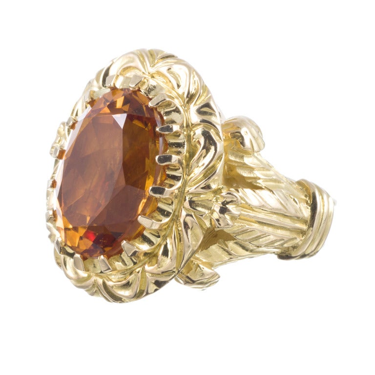 18k yellow gold ring, substantial in size and design, with scrolling waves of golden texture surrounding a 13 carat oval citrine. The ring is sizable on request. The top measures 1 inch by 1 inch.